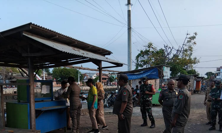 HARUS STERIL: Personel Satpol PP memberi surat peringatan pertama terhadap PKL yang berjualan di sepanjang trotoar Pelabuhan Pasuruan, Senin (11/8) so