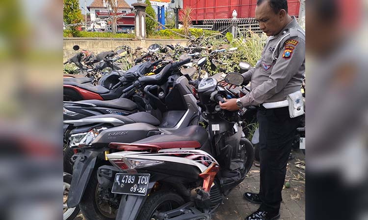 BARANG BUKTI: Petugas lantas menunjukkan dua motor yang terlibat tabrakan di Gambiran, Prigen, Kabupaten Pasuruan.