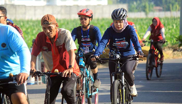 KEILING: Kepala Kantor Perwakilan BI Malang, Febrina (kanan) ikut gowes menyusuri sepanjang rute di Kraksaan.