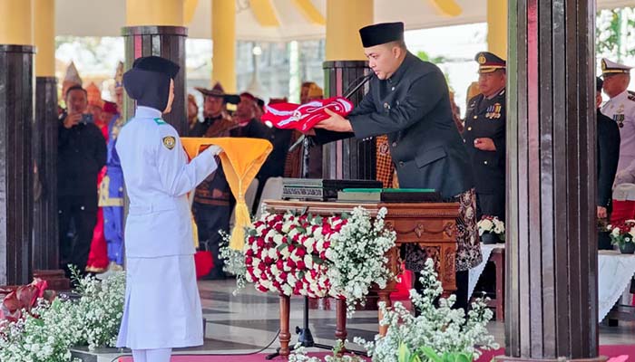Bupati Pasuruan Mas Rusdi saat memberikan sang saka merah putih ke petugas Paskibraka untuk dikibarkan.