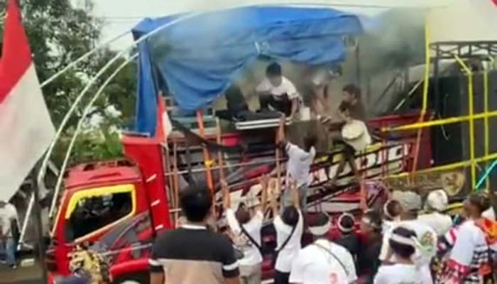 BIKIN PANIK: Sejumlah peserta pawai berupaya memadamkan genset sound yang alami korslet saat karnaval berlangsung.