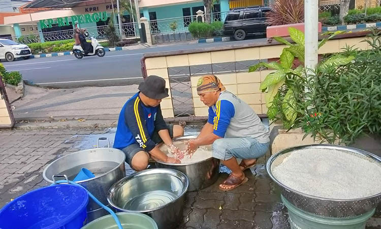 SUDAH TERBIASA: Personel Tagana Kota Pasuruan saat memasak di dapur umum di kantor Dinsos Kota Pasuruan saat terjadi bencana banjir.