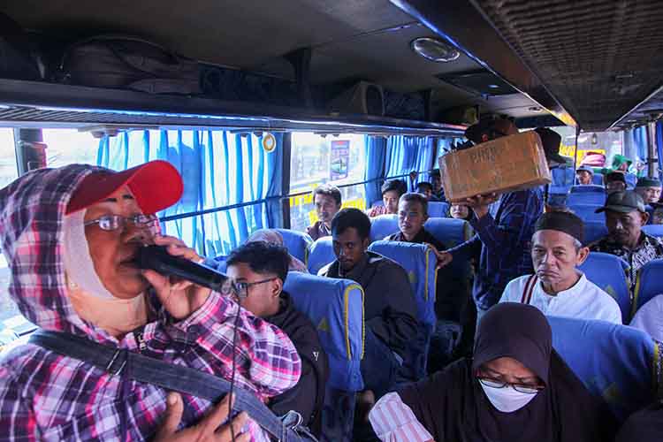 RAMAI: Seorang pengamen menghibur sejumlah penumpang salah satu bus di Terminal Bayuangga, Kota Probolinggo, Selasa (19/8).