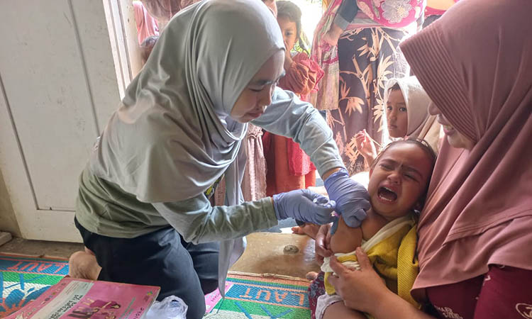 BIAR KEBAL: Petugas kesehatan Desa Tambelang, Kecamatan Krucil sedang melakukan imunisasi pada balita. Penyebaran penyakit campak kian diwaspadai.