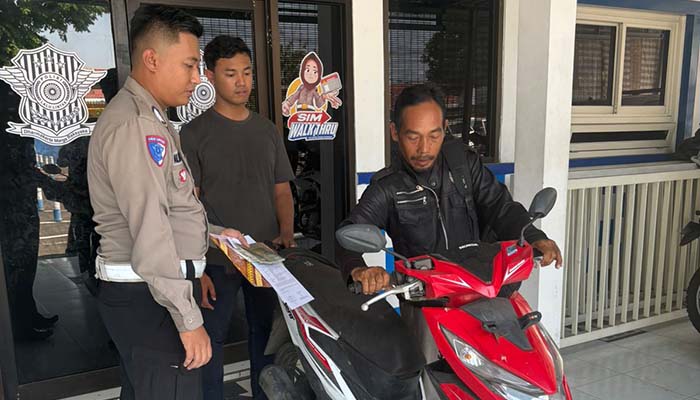 KEMBALI: M Athoillah, 55, saat menuntun motornya yang sempat hilang selama tujuh bulan.