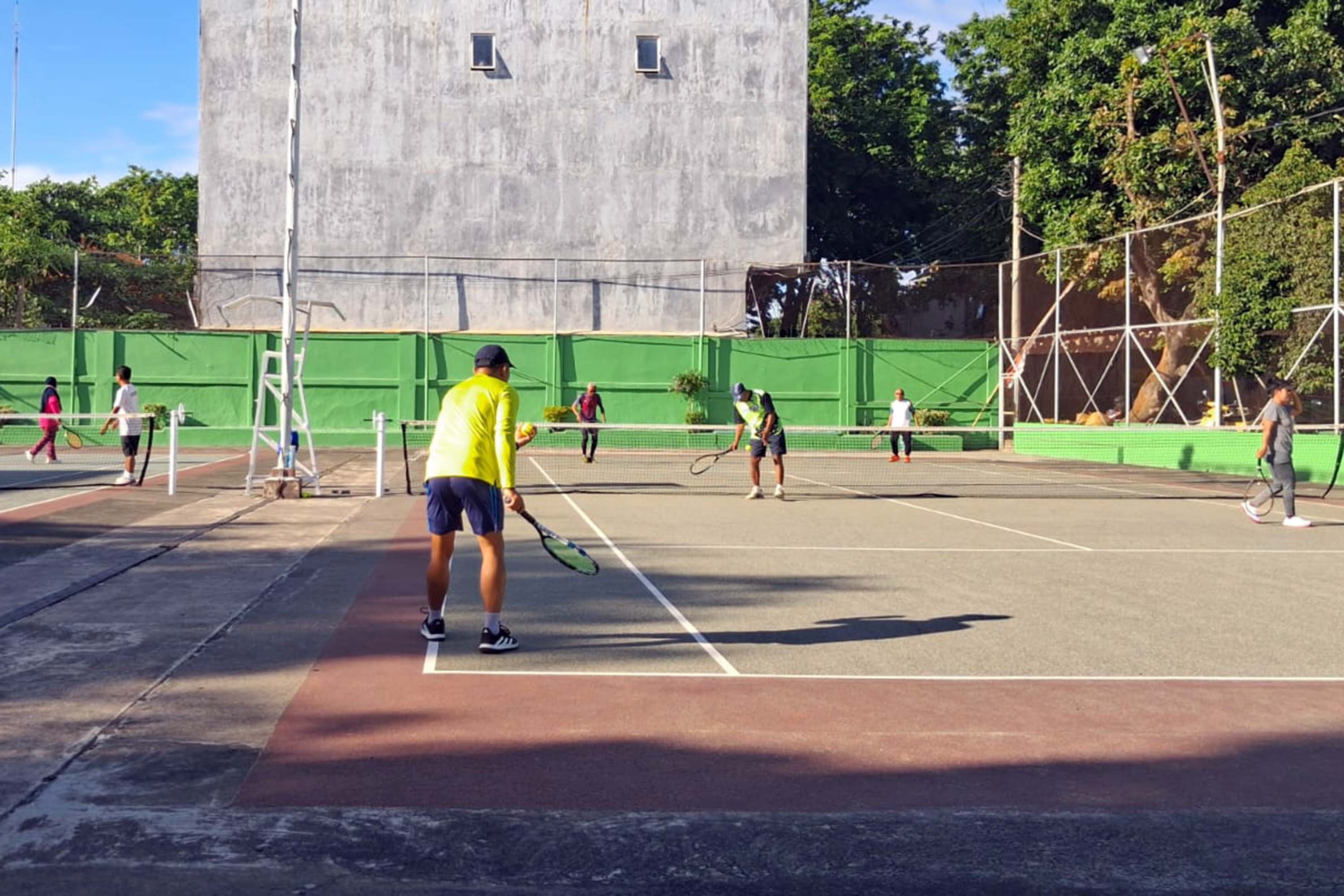 BELUM PUNYA INDOOR: Warga Kota Probolinggo saat main tenis di lapangan Tenesan. (Arif Mashudi/ Radar Bromo)