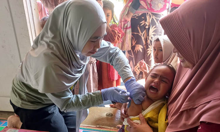 IMUNISASI: Petugas kesehatan Desa Tambelang, Kecamatan Krucil sedang melakukan imunisasi pada balita. Penyebaran penyakit campak kian diwaspadai.