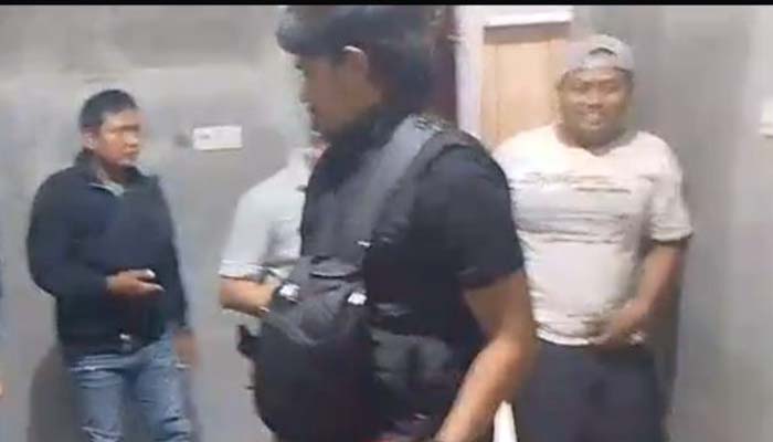D (pakai topi, kanan) saat dijemput polisi di rumahnya, Desa Besuk, Bantaran, Probolinggo.