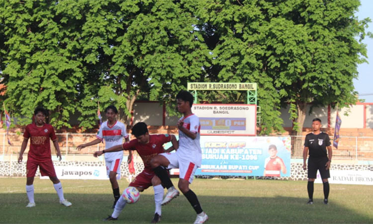 DIKEPUNG: Striker Winongan Maju FC Agies Armediansyah (merah) dikawal pemain Prigen FC saat berlaga di stadion R Soedrasono, Pogar, Bangil, Selasa (2/9) sore.