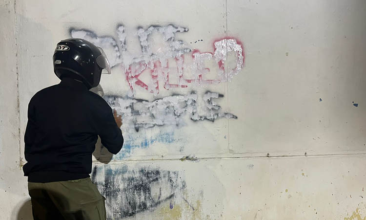 HAPUS: Petugas Satpol PP Kota Pasuruan saat melakukan penghapusan terhadap grafiti yang dianggap provokasi yang ditujukan kepada instansi kepolisian.