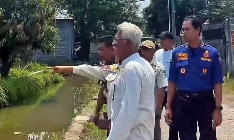 TINJAU: Kepala Satpol PP Kabupaten Pasuruan, Rido Nugroho bersama anggotanya saat meninjau saluran irigasi di Winongan. Di sana, banyak ditemukan bangunan rumah warga yang berdiri di atas saluran air.