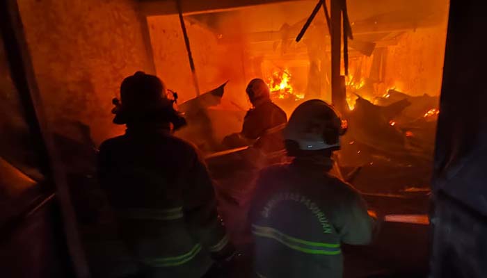 BERJIBAKU: Damkar dari Kota dan Kabupaten Pasuruan memadamkan api yang membakar gudang mebel Bintang Makmur di Jalan Jendral A. Yani Kota Pasuruan.
