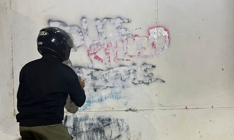 SEBELUM DIHAPUS: Tulisan yang bernada provokatif dihapus petugas Satpol PP. Saat ini polisi sedang memburu pelakunya.