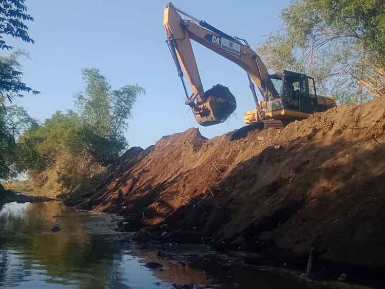 DIKERUK: Pekerja menggunakan ekskavator melakukan normalisasi di Sungai Pesisir, Kecamatan Sumberasih, Kabupaten Probolinggo.