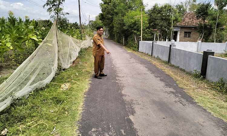 MULUS: Bendahara Desa Tegalsiwalan Rudi Hariyanto melihat jalan aspal di RT 8/RW 2, Dusun Sumbermuning yang sudah terealisasi.