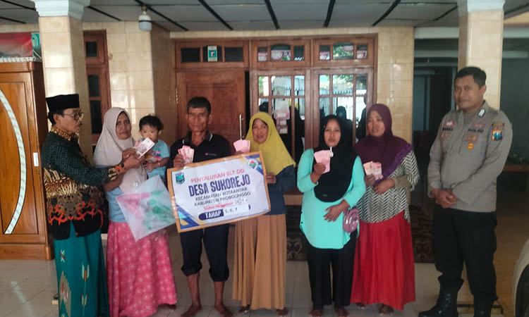 RINGANKAN BEBAN: Kepala Desa Sukorejo H. Abdul Halim (baju batik) menyerahkan BLT DD kepada penerima manfaat.