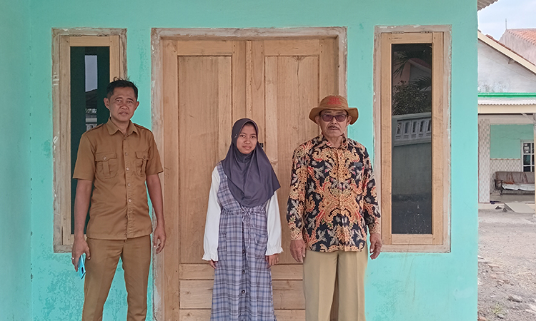 LEBIH LAYAK: Kepala Desa Sukorejo H. Abdul Halim (baju batik) didampingi Sekretaris Desa Ahmad Rofiki bersama penerima manfaat rehab rumah tak layak huni di Dusun Krajan RT RW 7/2.