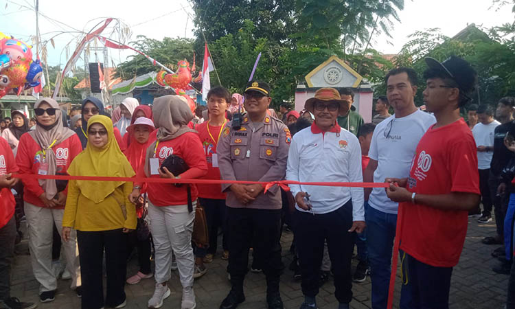 MERIAH: Kepala Desa Sukorejo H. Abdul Halim (pegang gunting) saat memotong pita pelaksanaan jalan sehat HUT Ke-80 RI bersama seluruh masyarakat Desa Sukorejo