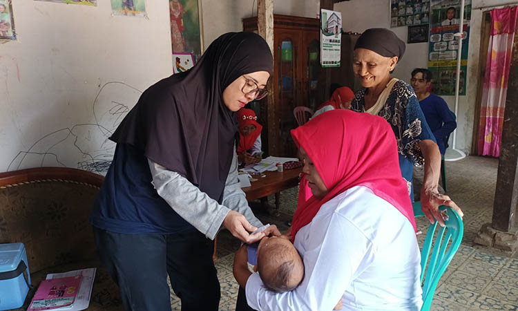 SEHAT: Petugas Kesehatan memberikan vaksin kepada seorang balita saat kegiatan Posyandu.