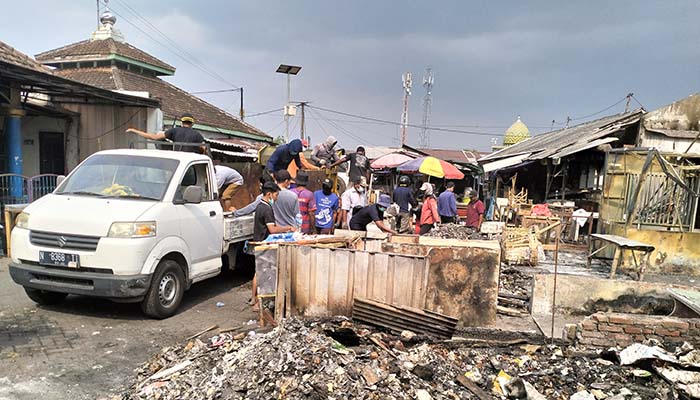 BERSIH-BERSIH: Petugas Pasar Pandaan bersama ratusan pedagang yang terdampak kebakaran kerja bakti membersihkan material sisa kebakaran di Pasar Pandaan, Selasa dan Rabu (9-10/9).