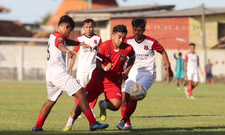 KEPUNG: Second striker Pandaan M Fatoni Majid (kostum merah) mencoba melepaskan diri dari kawalan pemain Kraton FC, dalam laga di Lapangan Plumnon, Pandaan, Kamis (11/9) sore.
