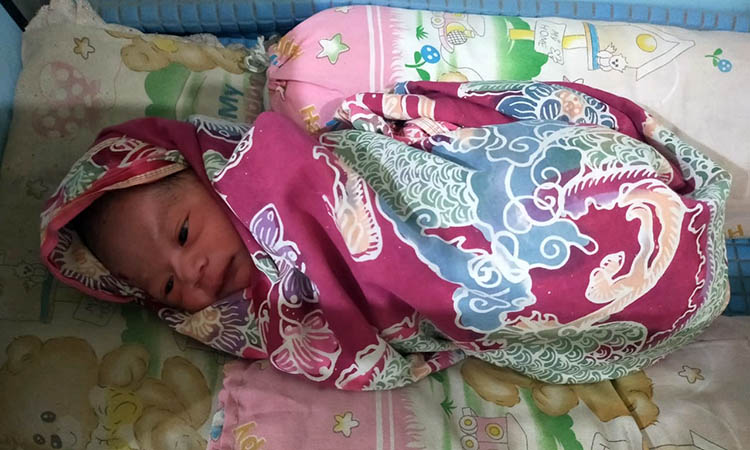 DIDALAMI: Bayi lelaki yang ditemukan di lahan bekas kolam lele Desa Gununggangsir, Kecamatan Beji, Kabupaten Pasuruan. Polisi kini memburu ayah biologis si bayi.