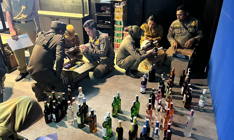 ANGKUT: Satpol PP Kabupaten Pasuruan saat mengamankan botol-botol miras yang ada di Toko Ultra, kawasan Terminal Pandaan. Meski baru digerebek, pemiliknya nekat kembali menjual barang terlarang itu.