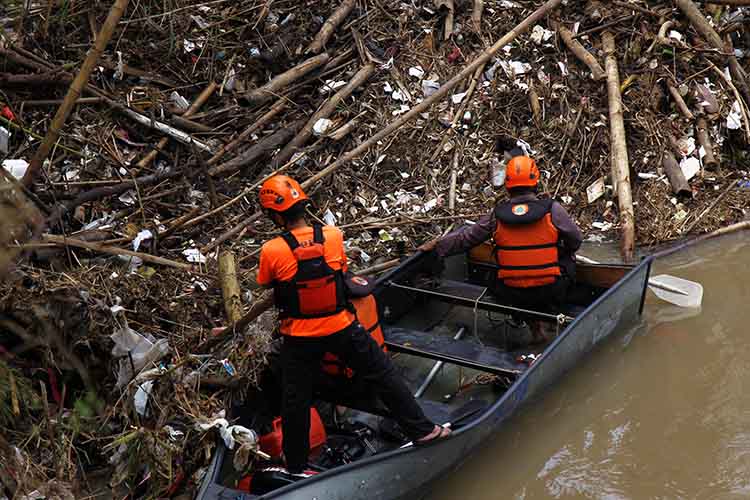 MENUMPUK: Sejumlah petugas berusaha membersihkan sampah yang menumpuk di Sungai Gembong, Kota Pasuruan, beberapa waktu lalu.