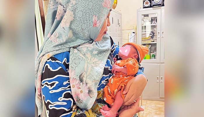 NYENYAK: Kepala Puskesmas Sumberasih, dr. Imelda Kusumaningrum menggendong bayi LL yang ditemukan di sebuah pos ronda Dusun Bringin, Desa Pohsangit Leres, Sumberasih, Kabupaten Probolinggo.