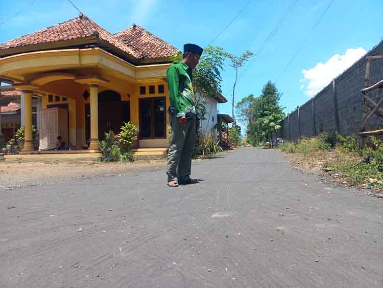 ⁠NYAMAN: Kepala Desa Kareng Kidul Suladi mengecek lokasi pengaspalan jalan di Dusun Petung.