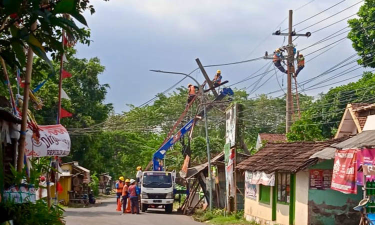 DIPERBAIKI: Petugas PLN sedang memperbaiki tiang listrik yang patah karena pohon tumbang di Desa Condong, Kecamatan Gading.