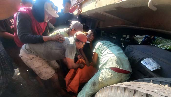 BUTUH WAKTU: Proses evakuasi korban kecelakaan maut terlindas truk kontainer di jalur pantura Bayeman, Tongas, Probolinggo. (Inneke Agustin/ Radar Bromo)