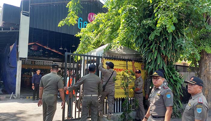 PASANG SEGEL: Tim Satpol PP Kota Probolinggo saat menutup mie Gacoan Probolinggo di Jalan Suroyo, Kota Probolinggo.