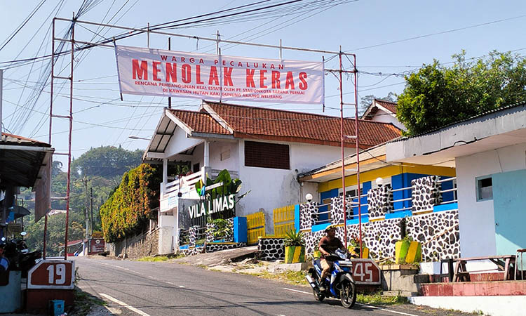 BANNER PENOLAKAN: Rencana pembangunan real estate di kaki Gunung Arjuno-Welirang yang berujung penolakan warga. Mereka menganggap, pembangunan tersebut sebuah ancaman terhadap lingkungan.