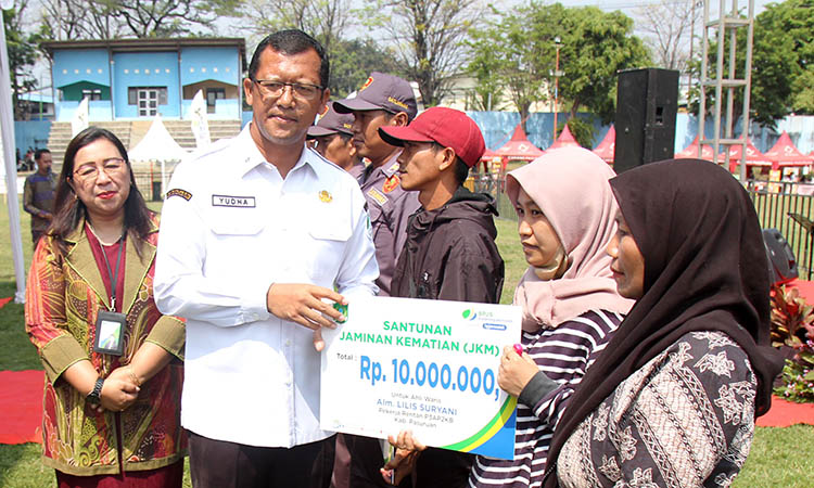 SANTUNAN: Sekda Kabupaten Pasuruan, Yudha Triwidya Sasongko saat berikan santunan jaminan kematian (JKM) bagi ahli waris pekerja yang meninggal dunia.