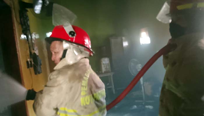 TERBAKAR: Petugas Damkar Satpol PP Kota Probolinggo memadamkan api di rumah Ubaidillah Hamdah, 48, warga Kelurahan/Kecamatan Kademangan, Kota Probolinggo, Rabu (24/9) pagi.