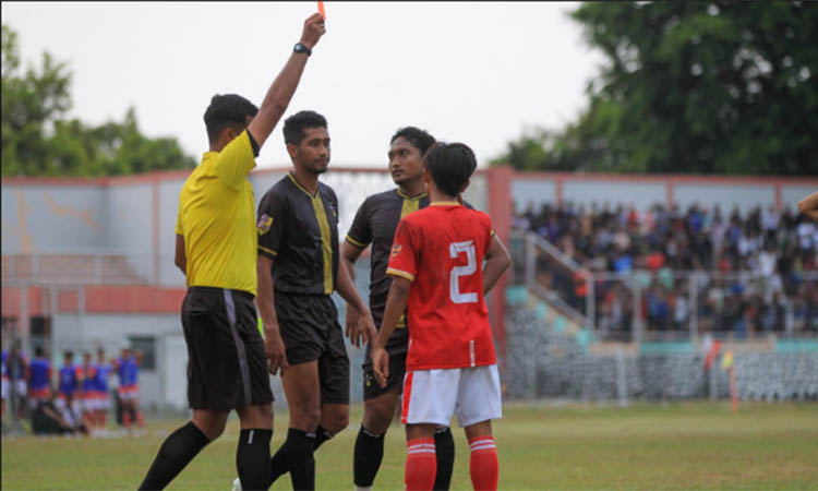 Wasit Haldy dari Malang mengeluarkan kartu merah untuk pemain Nguling FC
