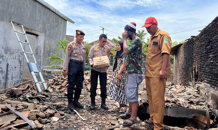 SERAHKAN: Petugas kepolisian saat menyerahkan bantuan kepada korban yang mengalami bencana kebakaran.