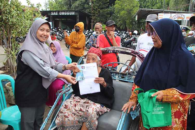 WONOASIH: Petugas di Kecamatan Wonoasih, dengan sigap melayani sepenuh hati salah satu KPM asal Kecamatan Wonoasih, yang tidak mampu berjalan.