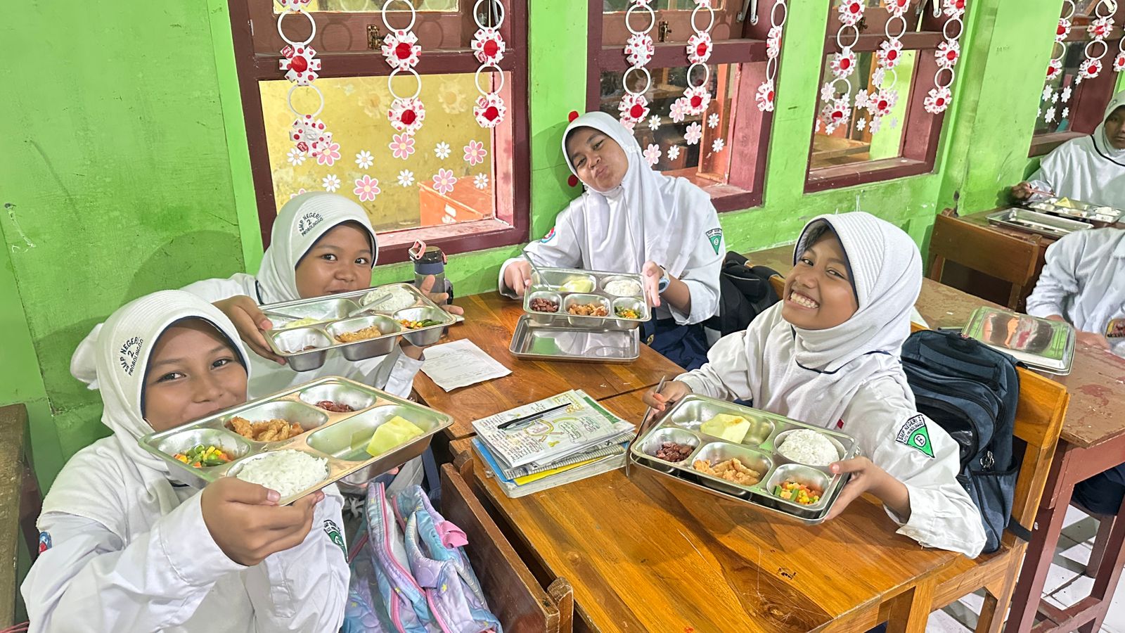 Sejumlah siswi SMPN 2 Kota Probolinggo menunjukkan menu MBG-nya.