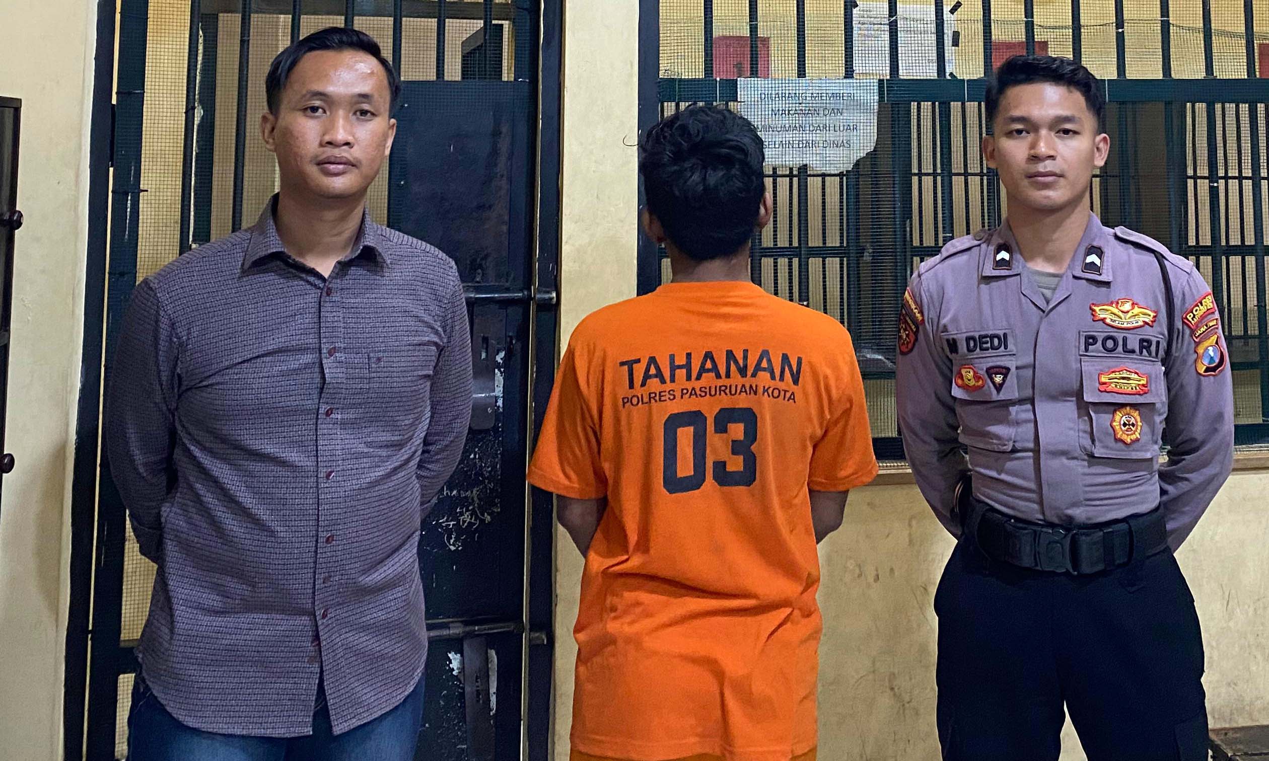 Pelaku Putra Budiman (membelakangi kamera) saat diamankan.