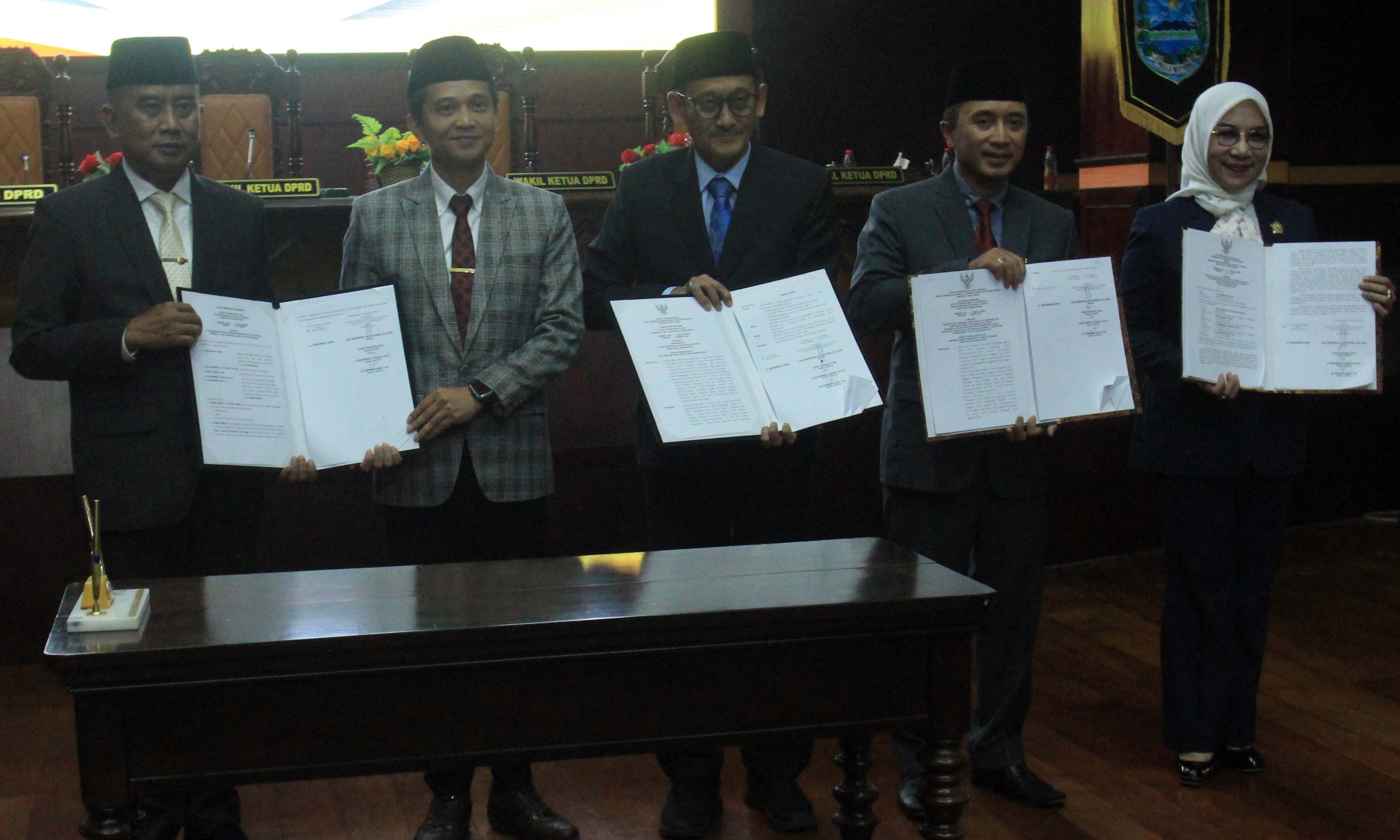 PERSETUJUAN: Ketua dan tiga wakil ketua DPRD Kabupaten Probolinggo bersama Sekda Kabupaten Probolinggo Ugas Irwanto menunjukkan nota persetujuan bersama untuk tiga Raperda dan KUA-PPAS APBD 2026.
