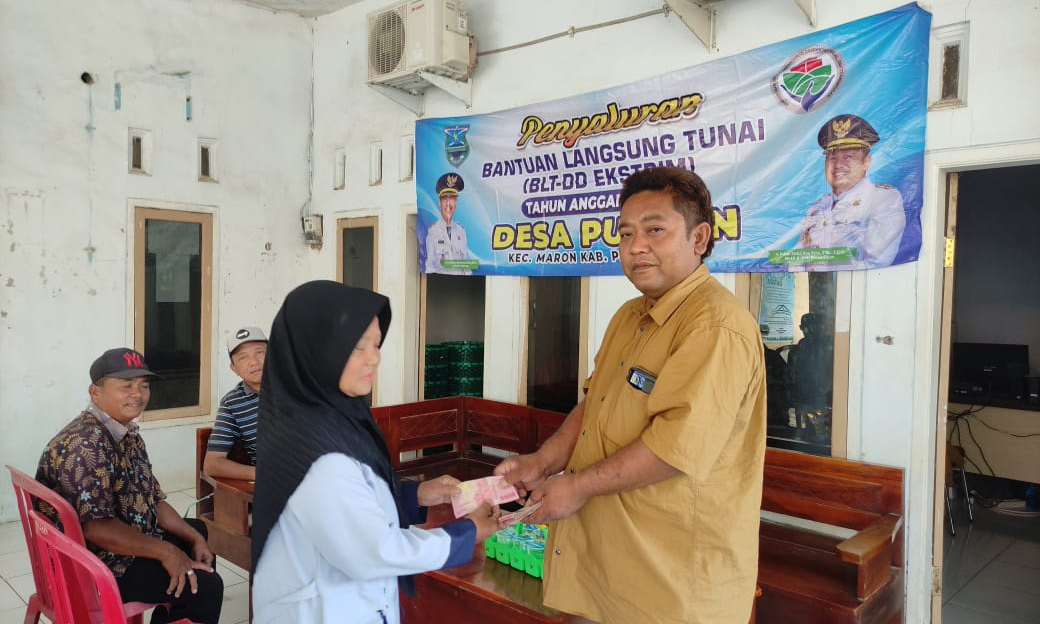 SALURKAN: Kepala Desa Puspan Umar menyerahkan BLT-DD kepada keluarga penerima manfaat.