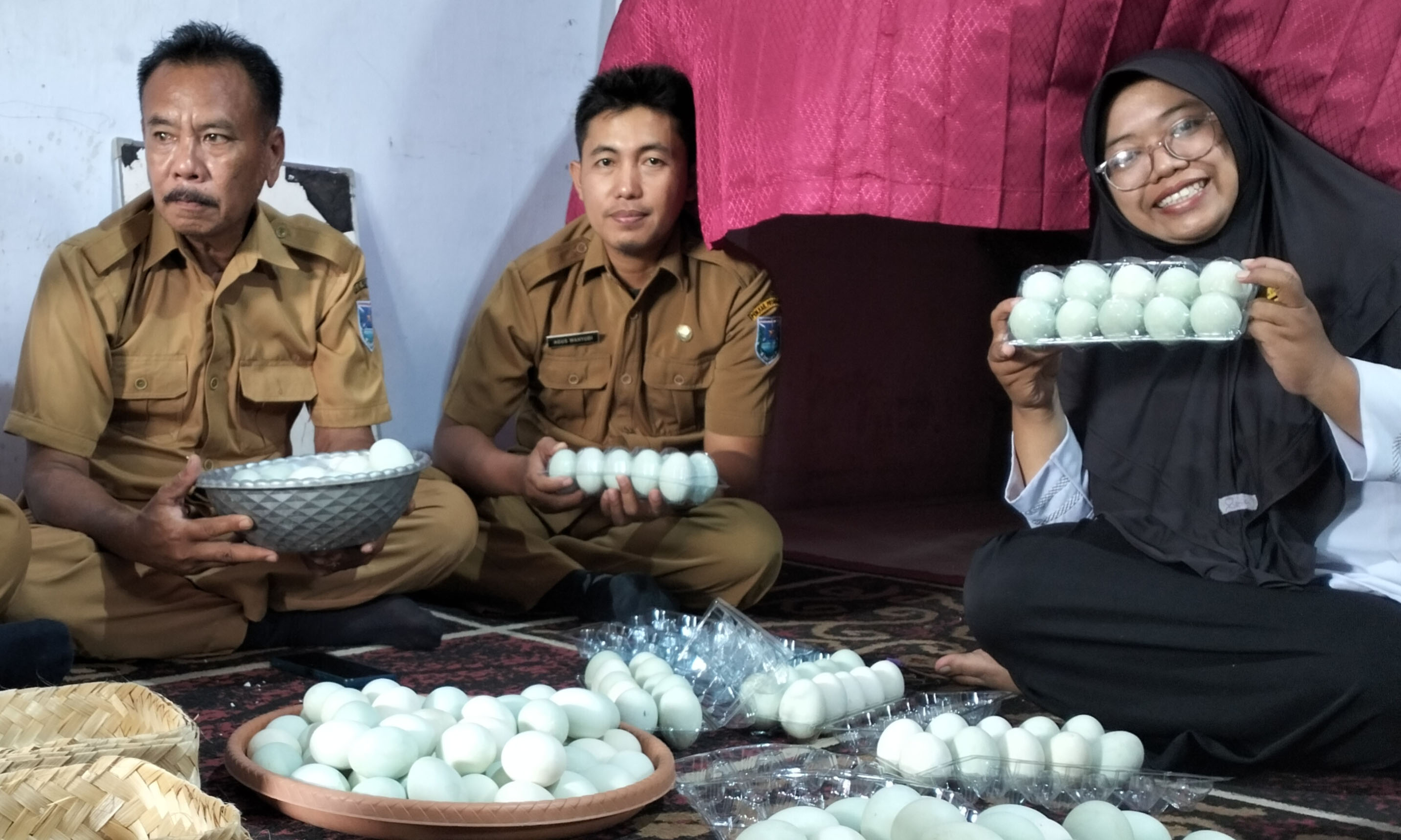 PRODUKTIF: Direktur BUMDes Wonorejo Kurnia Dewi bersama perangkat desa menunjukkan produksi telur asin yang kini memiliki banyak peminat.