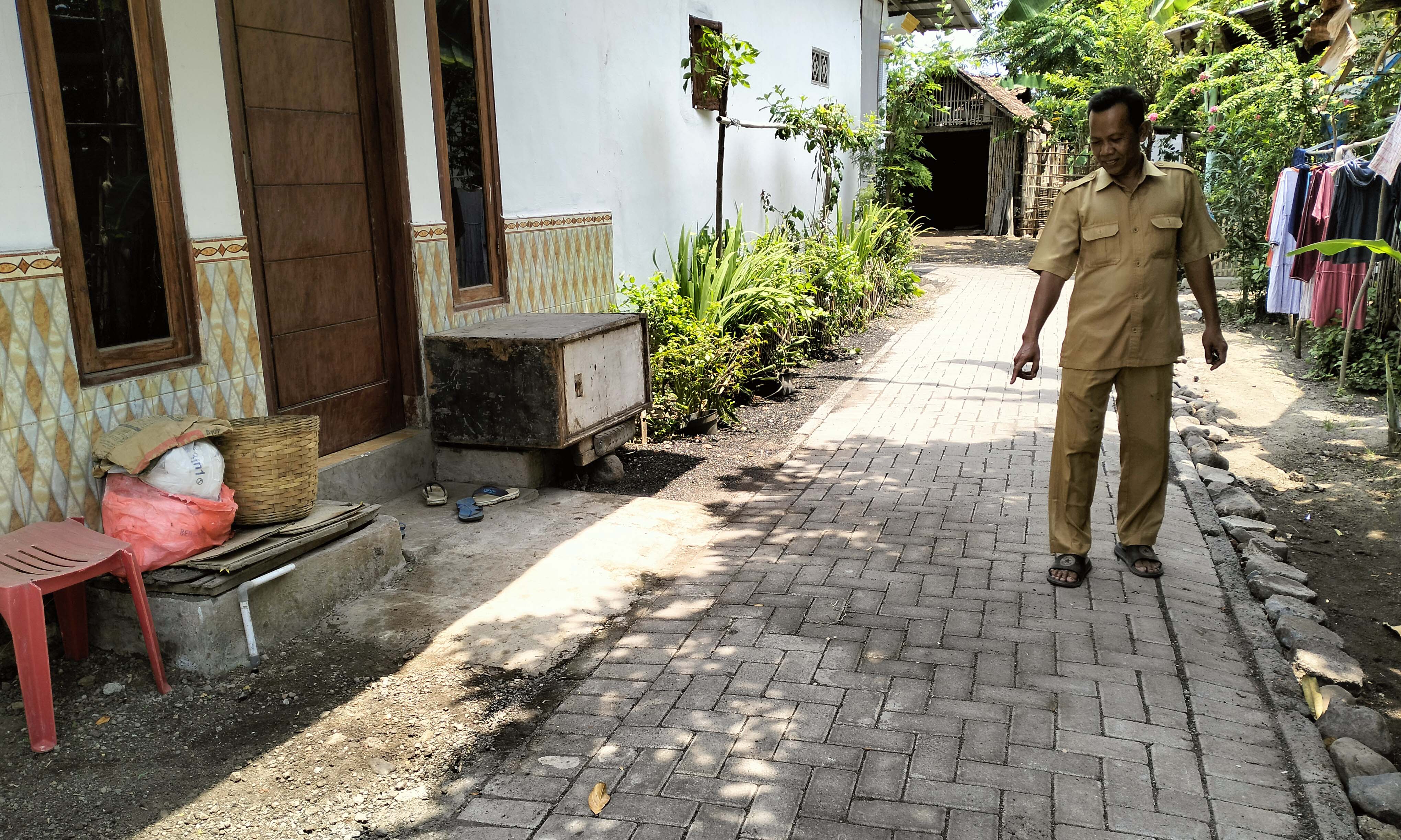 LEBIH NYAMAN: Operator Desa Wonorejo Sukardi menunjukkan jalan paving di RT 10/RW 3, Dusun Candi, yang sudah selesai dibangun.