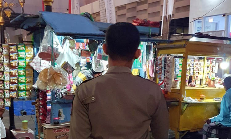 OPERASI: Salah satu petugas saat menyisir kawasan Alun-Alun Kota Pasuruan. Di kawasan setempat, ditemukan masih ada saja PKL yang melanggar.