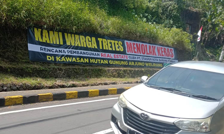 PENOLAKAN: Salah satu banner protes atas rencana pembangunan real estate di kaki gunung Arjuno-Welirang.
