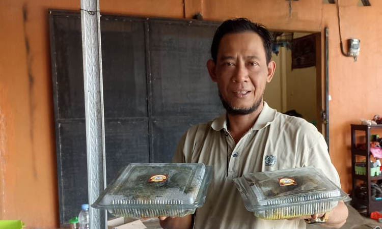 INOVATOR: Kepala Desa Maron Kulon, Hasan Basri memegang dua kemasan bebek ungkep yang dijual secara online.