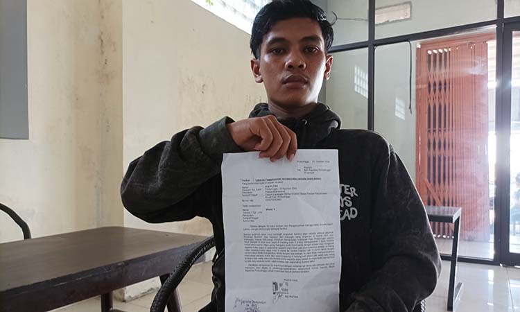 LAPOR POLISI Adi Putra 20, warga Desa Plaosan, Kecamatan Krucil saat mempelihatkan bukti laporannya kepolres Probolinggo atas kejadian premanisme oleh debt collector di alun-alun Kraksaan.