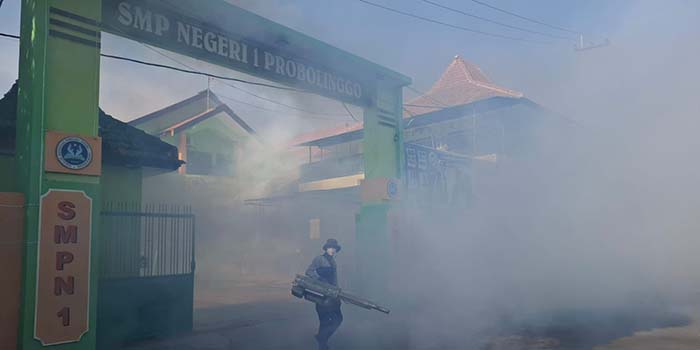 FOGGING: Petugas Puskesmas Sukabumi melakukan fogging di SMP Negeri 1 Kota Probolinggo, Jumat (10/10) pagi, setelah tiga siswa positif DBD.